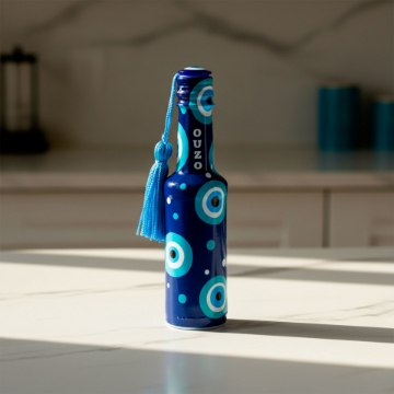 Ouzo Aperitif with Ice and Water A hand pouring cold water into a glass of elenianna ouzo over ice, showing the liquid transforming into a milky white color.