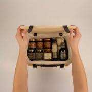 Full collection of Navarino Icons gourmet Greek products displayed in front of personalized wooden lid hamper.
